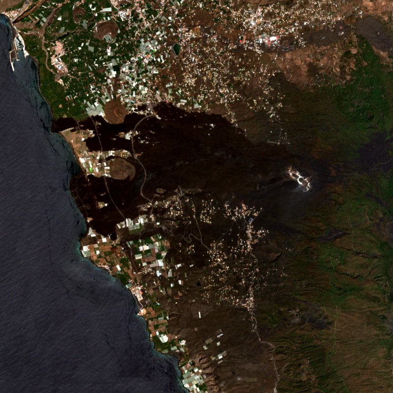 The same coast, September 2022: a black lava field runs from the vent to new land at the sea